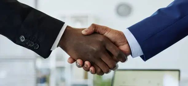 Close up of two business people shaking hands after successful partnership negotiation in office